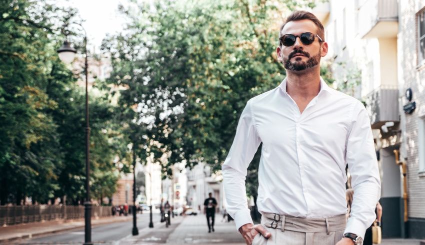 A man in a white shirt and tan pants standing on a street.