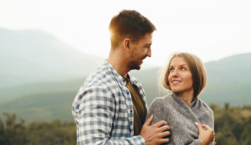 A man and woman looking at each other in the mountains.
