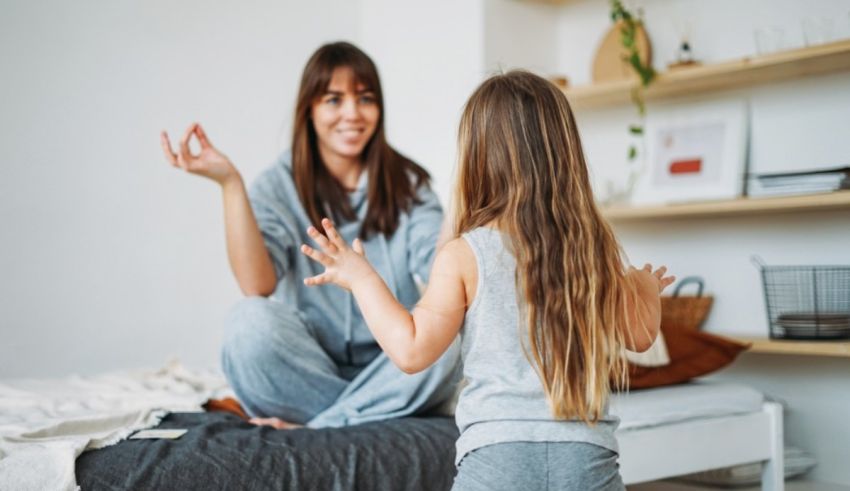 A mother and daughter sitting on a bed together.