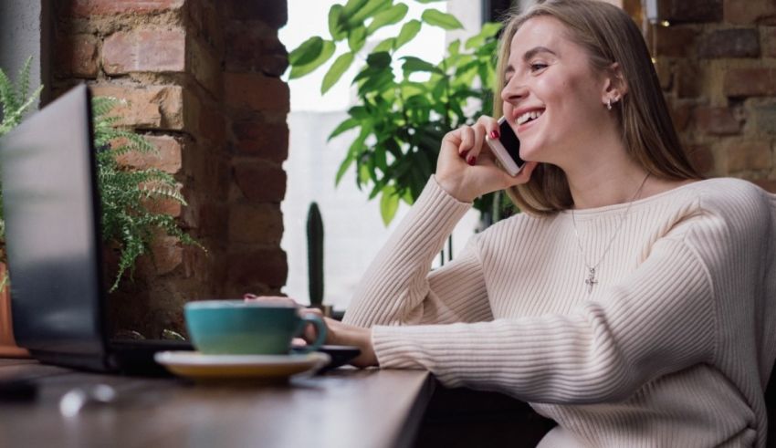 A woman is talking on the phone while sitting at a desk.