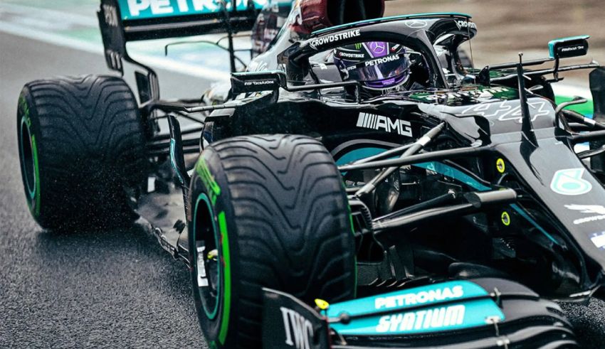 A mercedes f1 car on a wet track.
