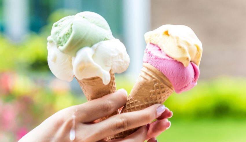 A woman is holding two cones of ice cream.