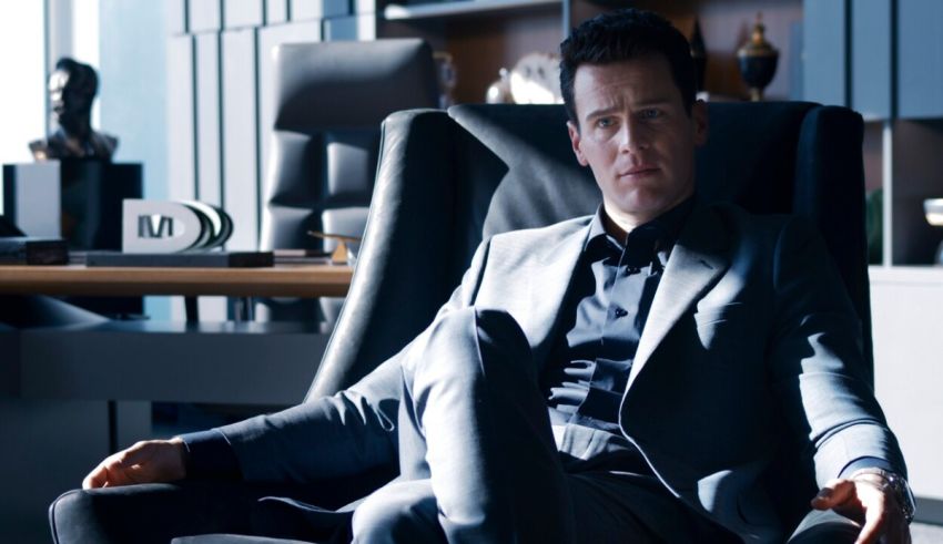 A man in a suit sitting in an office chair.