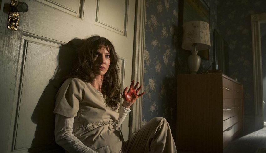 A woman sitting on the floor in front of a door.