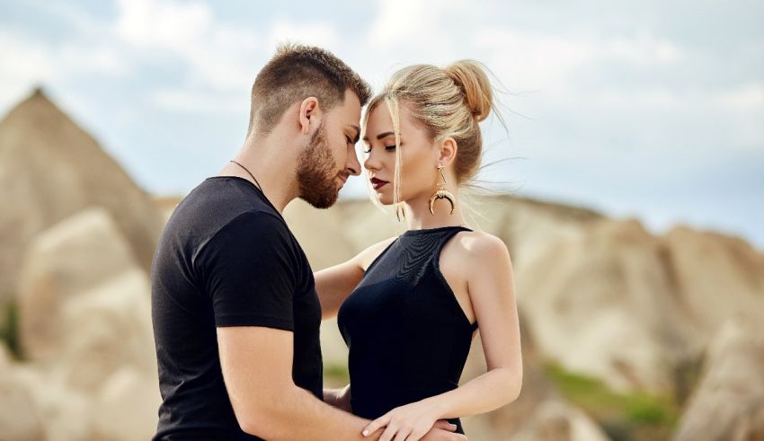 A man and woman are embracing in the desert.
