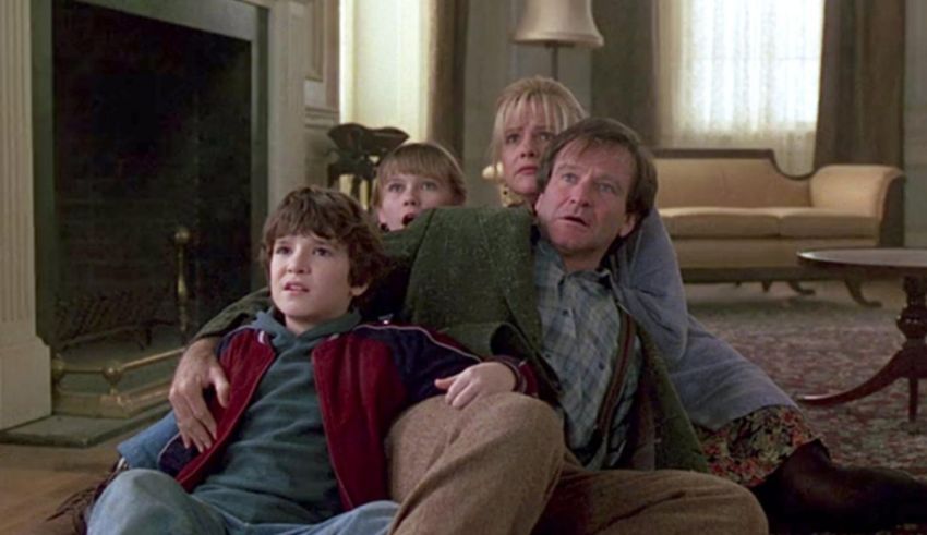 A family sits on the floor in front of a fireplace.