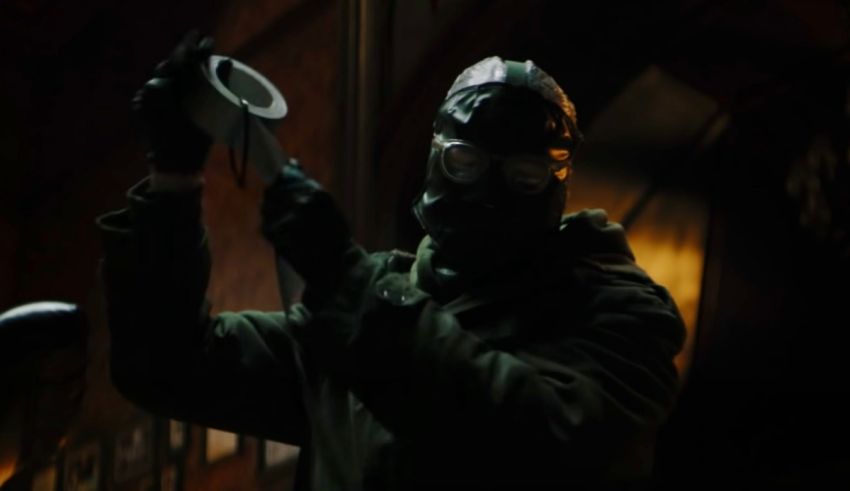 A man in a gas mask holding a cup.