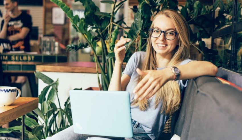 A young woman sitting on a couch with a laptop.
