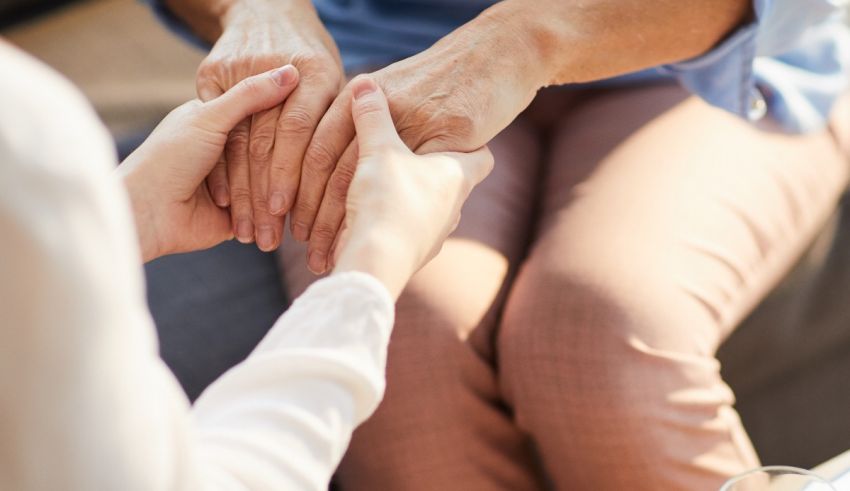A woman is holding an elderly woman's hand.