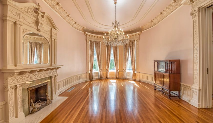 An empty room with pink walls and a chandelier.