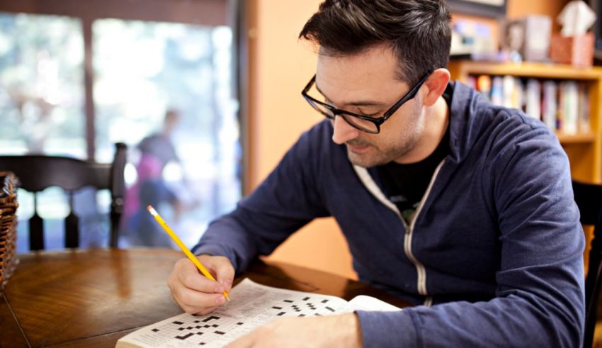 A man sitting at a table writing in a notebook.