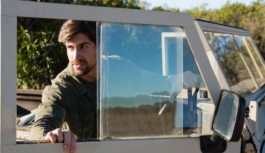 A man looking out the window of a jeep.