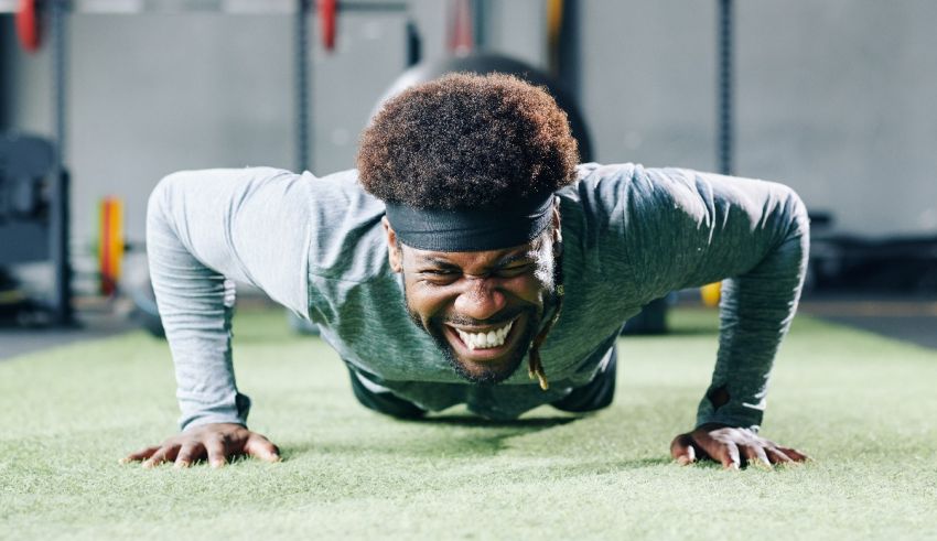 A man doing push ups in a gym.