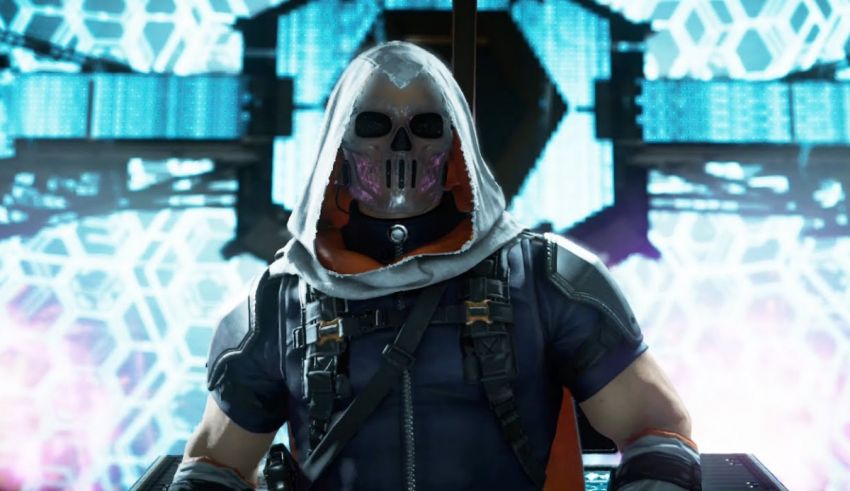 A man in a hooded outfit standing in front of a blue screen.