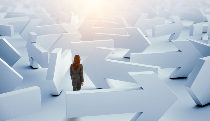 A business woman is standing in a crowd of arrows.