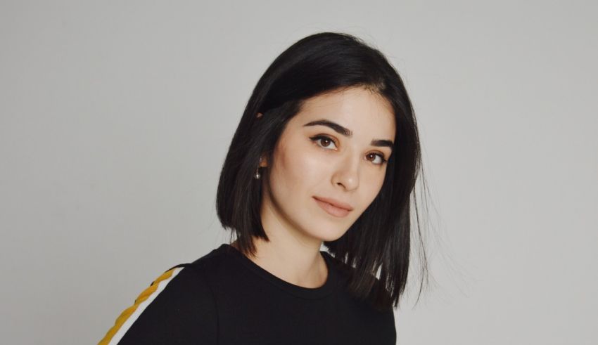 A young woman wearing a black top and yellow stripes.