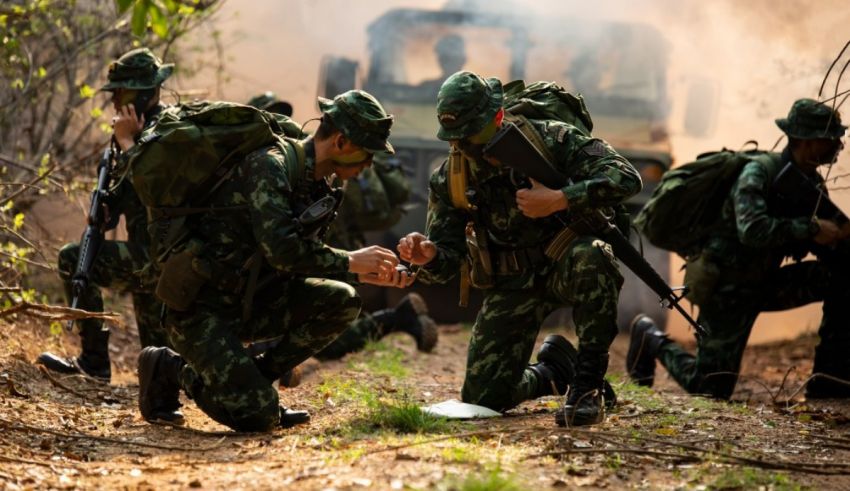 A group of soldiers in camouflage gear in a wooded area.