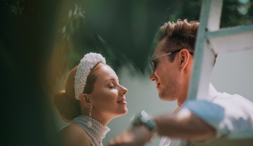 A bride and groom looking at each other while standing on a ladder.