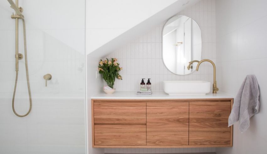 A white bathroom with wooden cabinets and a shower.