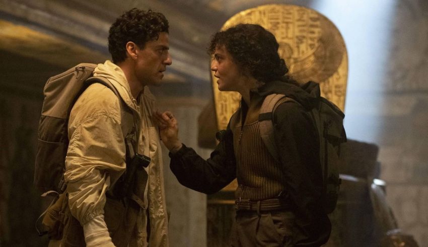 Two men standing next to each other in a dark room.