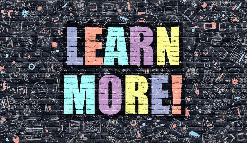 Learn more written on a brick wall with colorful doodles.