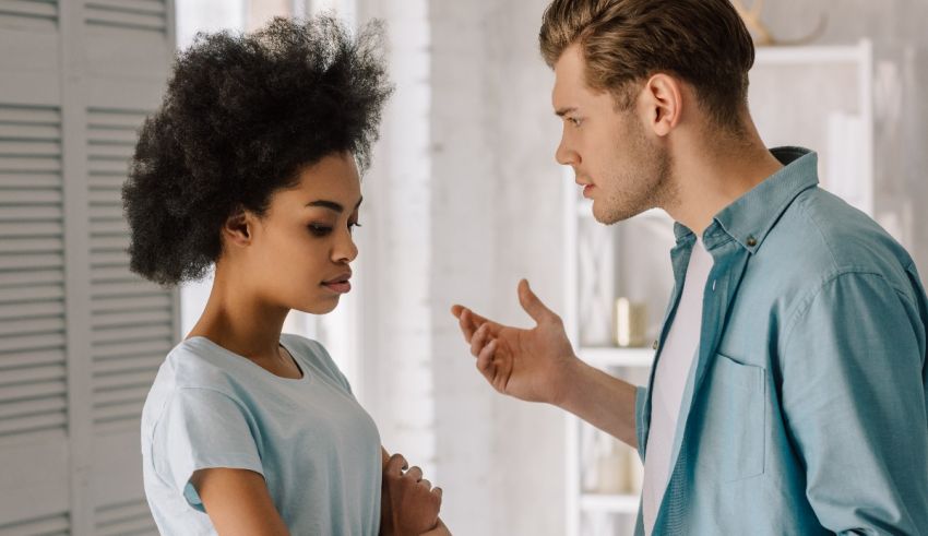A man and woman talking to each other in a living room.