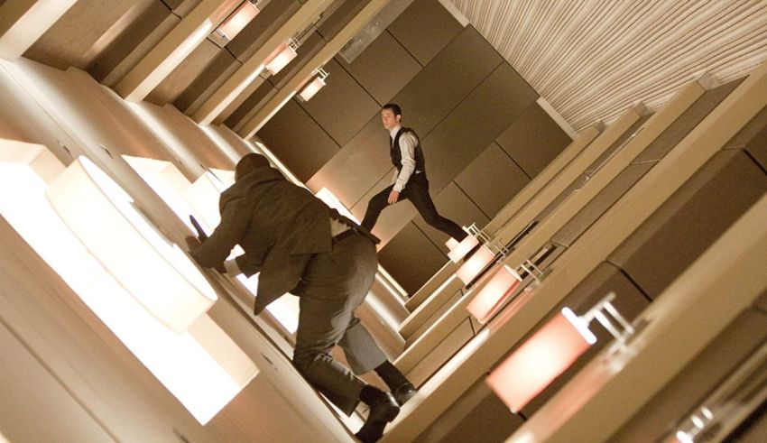 Two men in suits walking down a hallway.