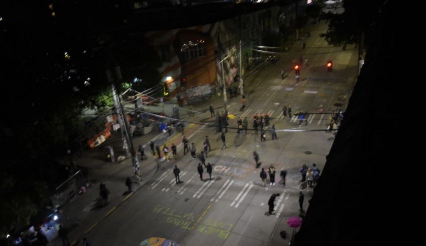 A group of people standing on a street at night.