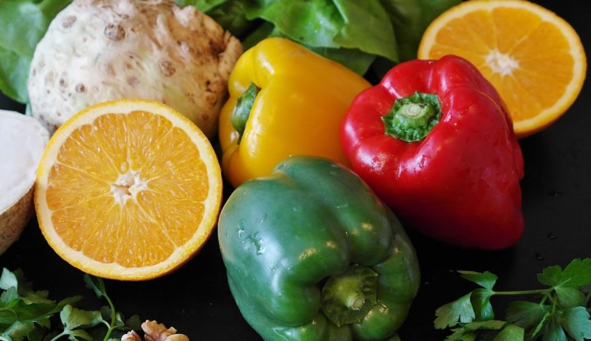 A variety of fruits and vegetables on a black surface.
