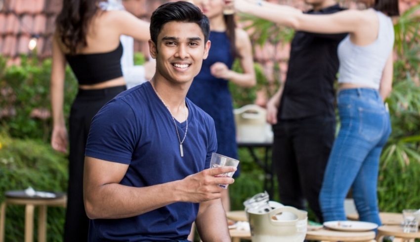 A group of people at a party with a man holding a glass of wine.