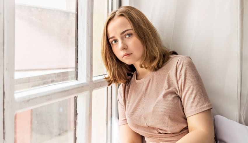 A young woman looking out of a window.