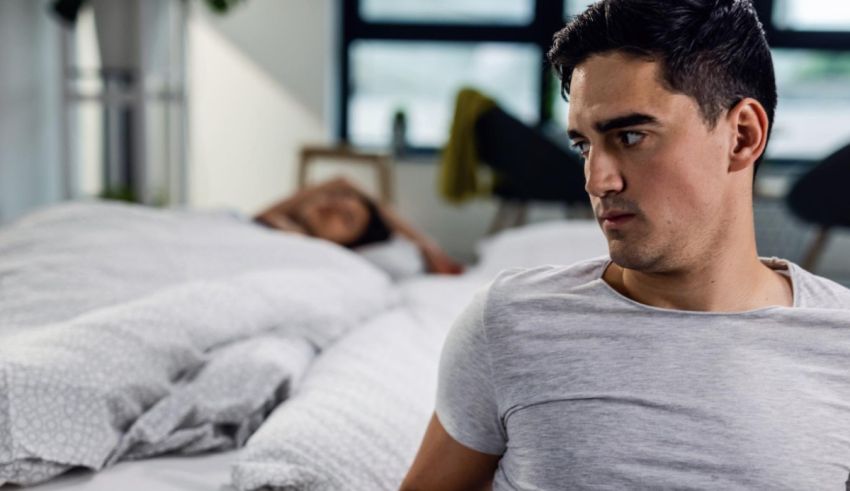 A man in bed with a woman looking at him.