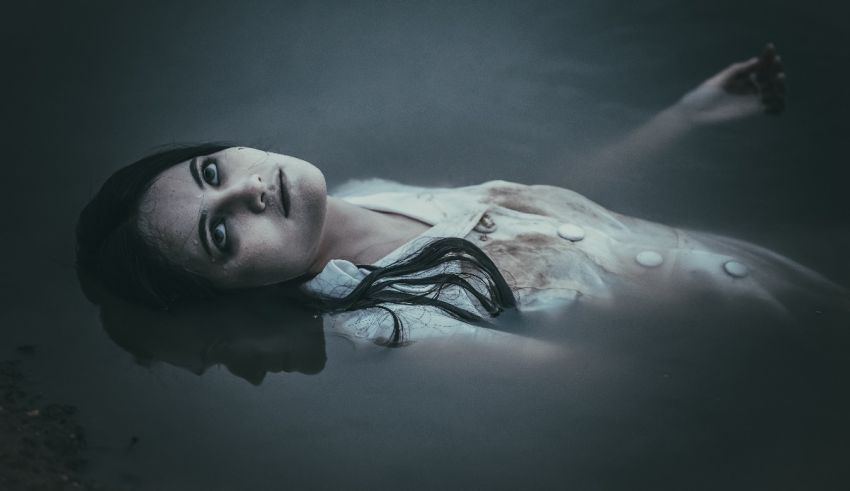 A woman laying in the water with her eyes closed.