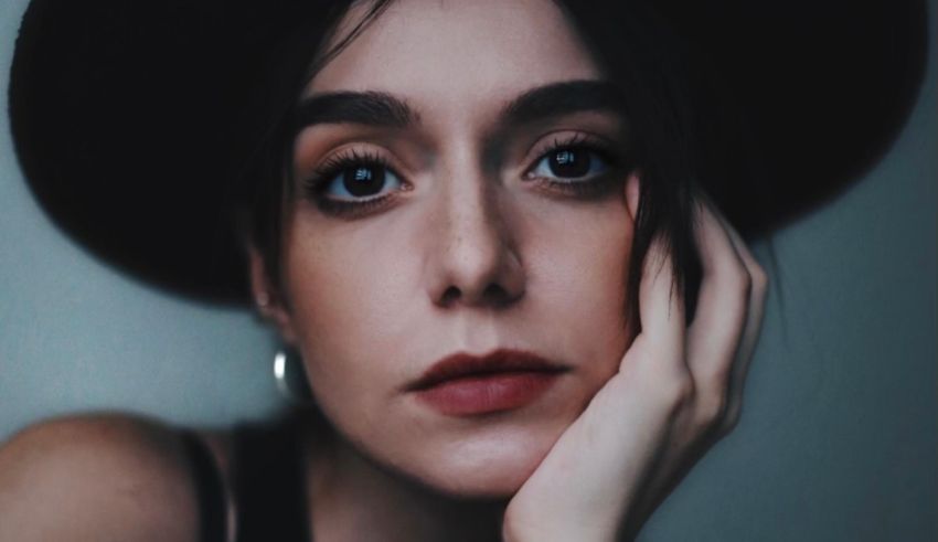 A woman in a black hat is posing for a photo.