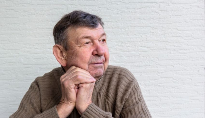 An older man with his hand on his chin.