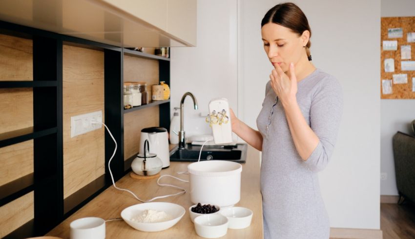 A woman is mixing ingredients in a kitchen.