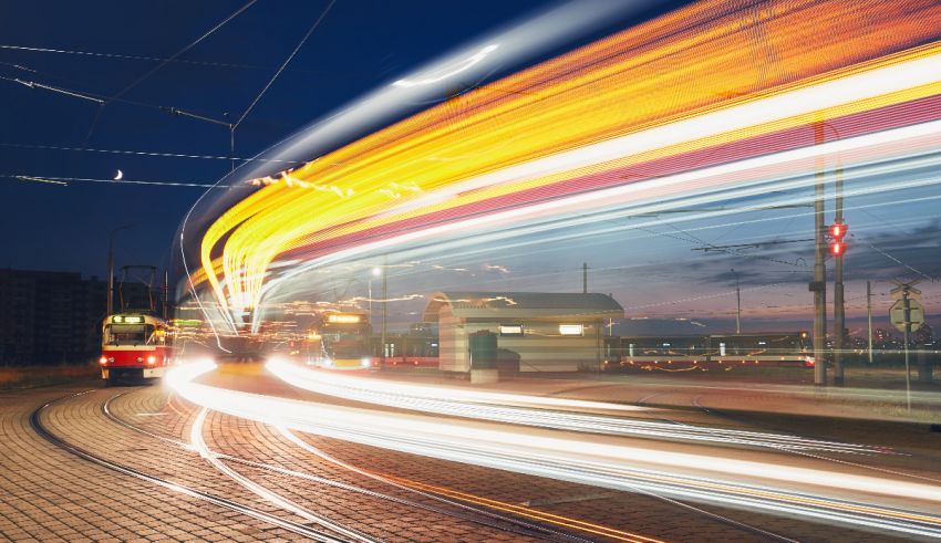 A train traveling down a street at night.
