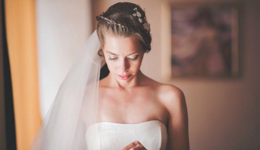 A bride in a wedding dress looking at her veil.