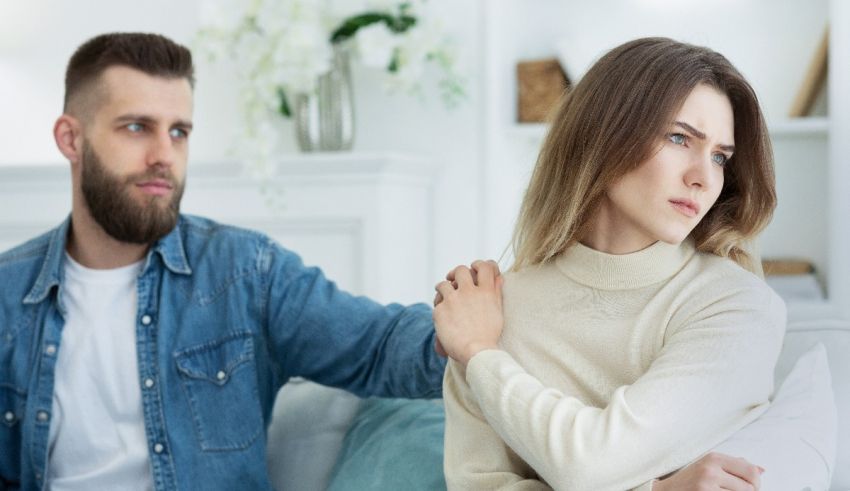 A man and woman sitting on a couch with their arms around each other.