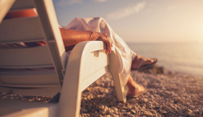 A woman is sitting in a chair on the beach.