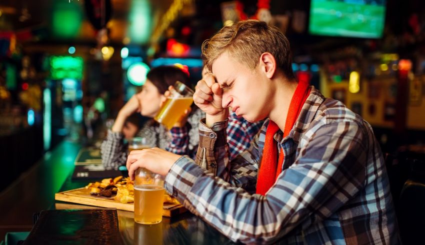 A group of people sitting at a bar and drinking beer.