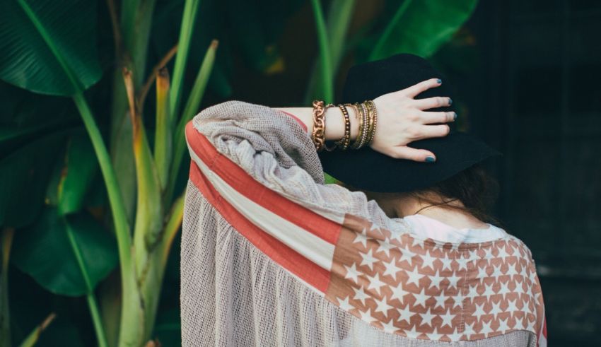 A woman wearing a hat and a patterned shirt.
