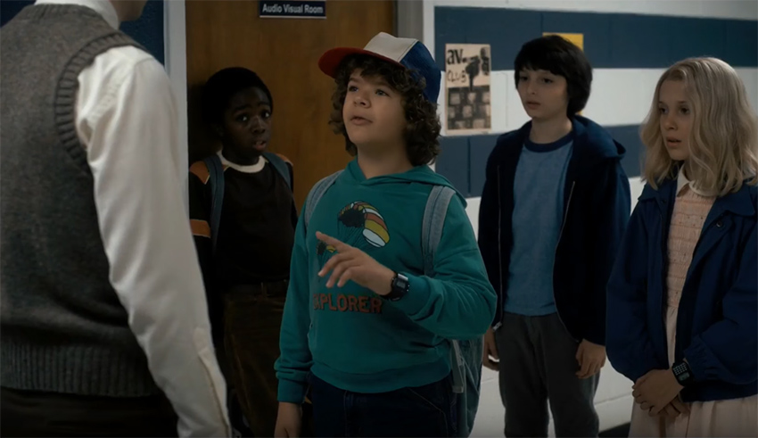 A group of children are standing in a hallway.