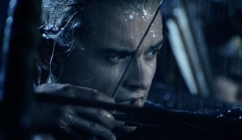 A man with a bow and arrow in the rain.