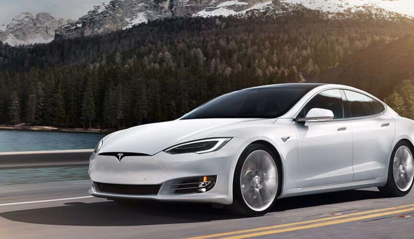 A white tesla model s driving down a mountain road.