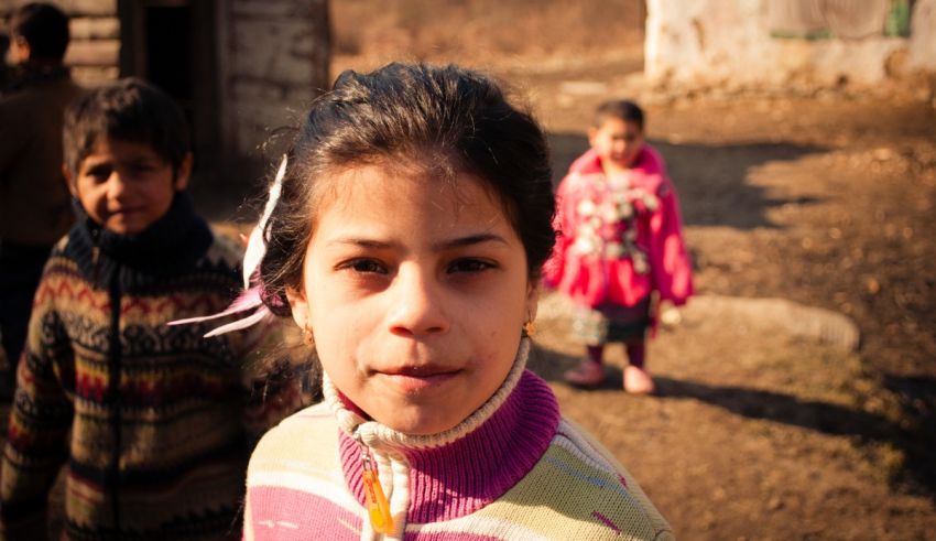 A girl is standing in front of a group of children.