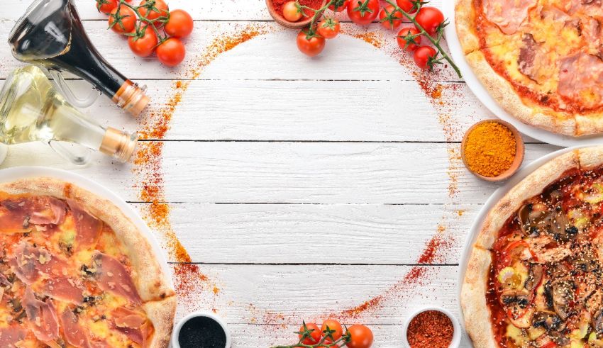 A group of pizzas on a white table.