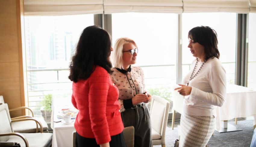 A group of women talking in a conference room.