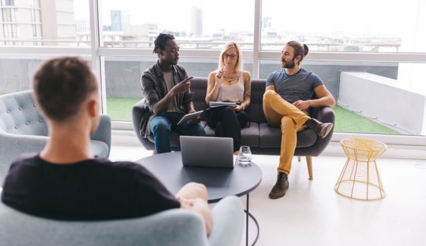 A group of people sitting around a table in an office.