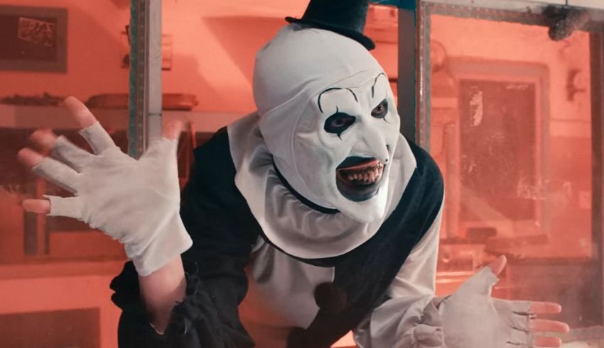 A clown in a white costume is standing in front of a window.